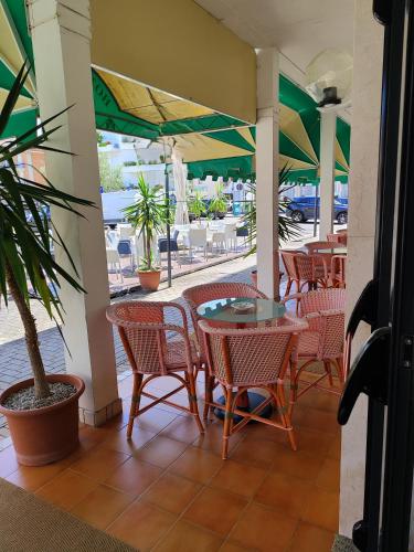 un patio con mesa y sillas y un patio con mesas y sillas en Hotel Trifoglio, en Lido di Jesolo