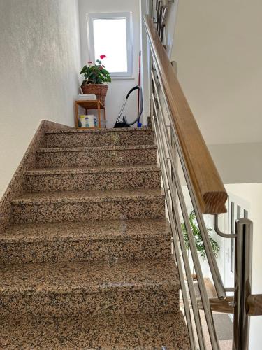 a stairway with a wooden handrail and a stair case at Apartments Nevenka i Josko in Tučepi