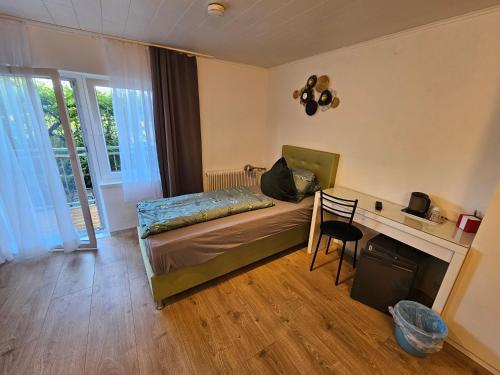 1 dormitorio con cama, escritorio y sofá cama en Pension Waldesruh, en Velden am Wörthersee