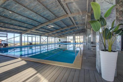 a large indoor swimming pool with a large ceiling at Vzmorie Resort Hotel in Bosteri