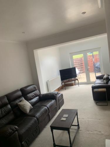a living room with a couch and a table at 4 Bedroom house with parking, Near Safari Park in Kidderminster