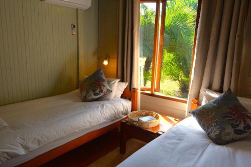a small room with two beds and a window at Sodwana Bay Lodge House 58 in Sodwana Bay