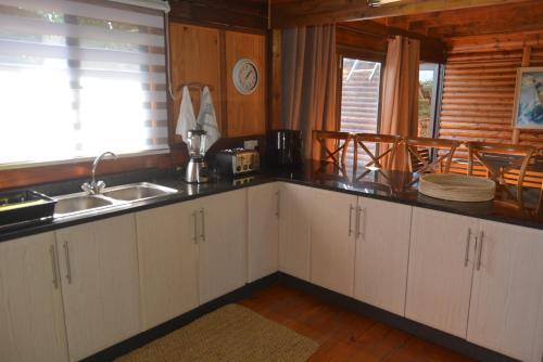 a kitchen with white cabinets and a sink and a window at Sodwana Bay Lodge House 58 in Sodwana Bay