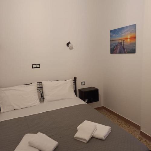 a bedroom with a bed with two towels on it at Διαμέρισμα 1 ΣΤΗΝ ΑΓΙΑ ΜΑΡΙΝΑ in Agia Marina Aegina