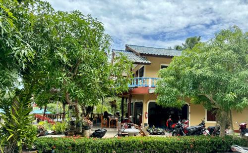 a house with a motorcycle parked in front of it at Baan Klong House in Baan Khai