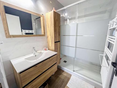 une salle de bain avec un lavabo et une douche dans l'établissement Bel appartement rénové au cœur de Jullouville, 100m de la plage, 1 chambre, 4 couchages, parking privé - FR-1-361-72, à Jullouville