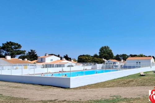 - une grande piscine en face de certaines maisons dans l'établissement Maison calme proche mer avec piscine, à Bretignolles-sur-Mer