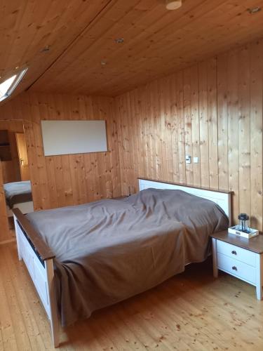 sypialnia z łóżkiem i drewnianą ścianą w obiekcie Urlaubstraum-gesamte Unterkunft w mieście Altglandorf