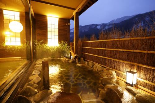 a hot tub in the middle of a house with lights at Onyado Yuinosho, Shirakawago in Shirakawa