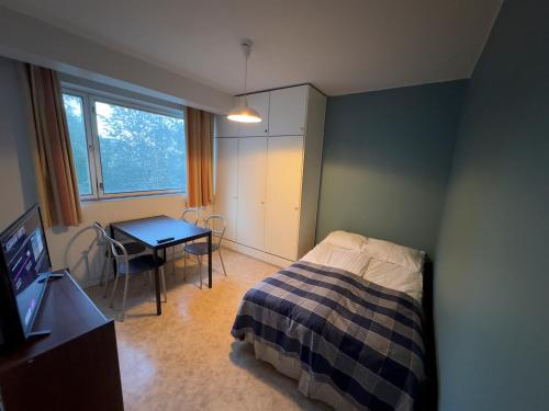 a bedroom with a bed and a table and a television at City Apartments Turku - 1 Bedroom Apartment with private sauna in Turku