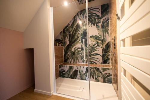 ein Badezimmer mit einer Treppe mit einem Wandbild aus Palmen in der Unterkunft Le Cocon chambre avec Jacuzzi privatif Normandie in Couvains