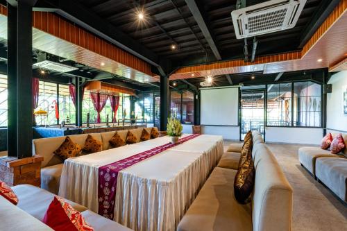a large room with a table and couches and a screen at Bali Sunshine Nusa Dua in Nusa Dua