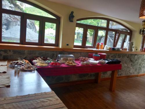 - une table avec de la nourriture dans une chambre avec des fenêtres dans l'établissement Hostel Quku i Valbones, à Valbonë