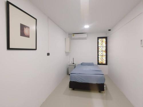 a bedroom with a bed in a white room at 辉煌夜市 4房泳池花园别墅 订4日提供免费接机 in Ban Na Song