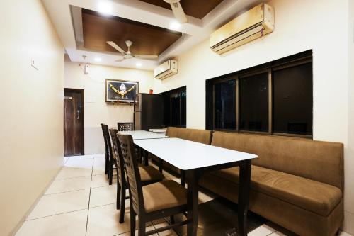 Hotel Airport Metro Near Chhatrapati Shivaji International Airport في مومباي: غرفة طعام مع طاولة وكراسي