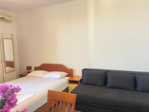 a bedroom with a bed and a couch at Apartments Radosevic in Ulcinj
