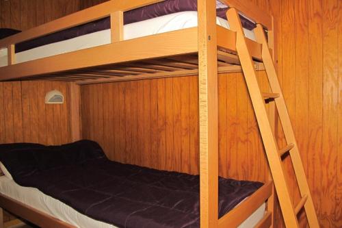 une chambre avec deux lits superposés et une échelle dans l'établissement Chalets les tutes de la Vernière, à Auzat