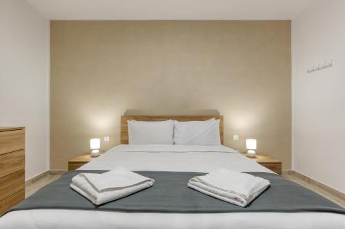a bedroom with a bed with two towels on it at Lavish 3bed In Fair Water Homes Swieqi By Homely in Is-Swieqi
