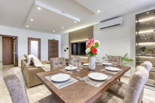 a dining room with a wooden table and chairs at Lavish 3bed In Fair Water Homes Swieqi By Homely in Is-Swieqi