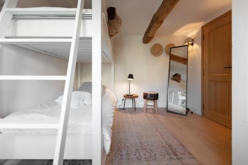 a bedroom with white bunk beds and a mirror at Mougins Luxury Retreats in Mougins