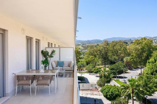 a balcony with a table and chairs and a view of a street at Ranhomes rentals apartments in Nueva Andalucia