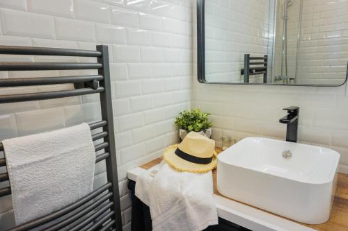 La salle de bains est pourvue d'un lavabo et d'un chapeau sur un comptoir. dans l'établissement -Le Phare- Front de mer a Concarneau avec balcon, à Concarneau