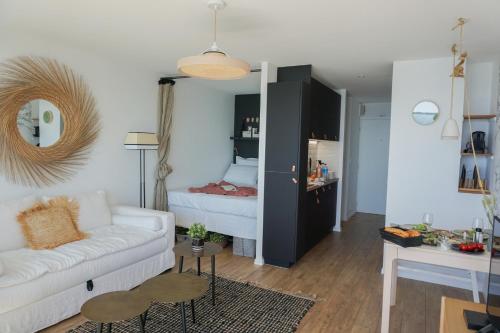 - un salon avec un canapé blanc et un lit dans l'établissement -Le Phare- Front de mer a Concarneau avec balcon, à Concarneau