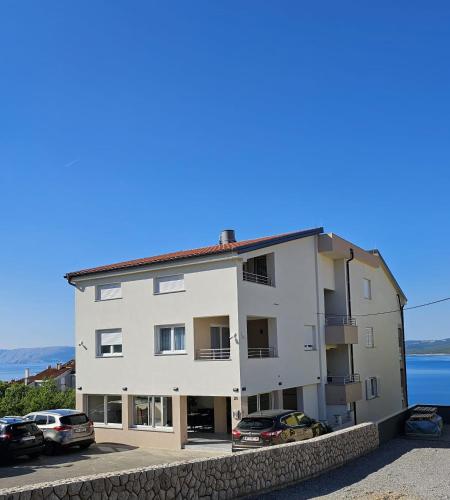 a white building with cars parked in front of it at Adria Mare in Crikvenica