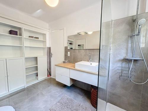 une salle de bain blanche avec un lavabo et une douche dans l'établissement MIA2 - 3 pièces avec terrasse, à Cannes