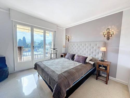 une chambre avec un grand lit et une grande fenêtre dans l'établissement MIA2 - 3 pièces avec terrasse, à Cannes