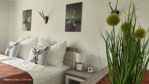 a bedroom with a bed with white pillows and a plant at Ferienhaus Strassgartl in Pinsdorf
