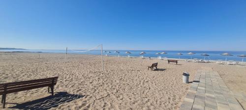 two benches on a beach with umbrellas and the ocean at Triblex Villa I Private Beach I Walking Distance to the Sea 300 meters in Side