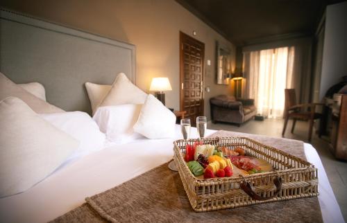 a basket of fruit on a bed in a hotel room at Hotel Swiss Moraira in Moraira