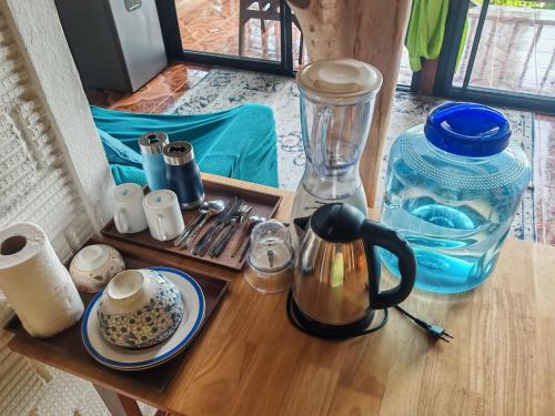 a wooden table with a tray of utensils and a blender at Pyramid Yoga Koh Phangan in Koh Phangan