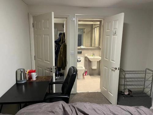 a bedroom with a door open to a bathroom with a sink at Room with Bathroom next to Sheffield Cathedral City Centre in Sheffield