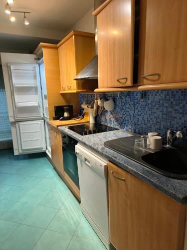 une cuisine avec des armoires en bois, un évier et un réfrigérateur dans l'établissement FREJUS-APPARTEMENT DEUX PIECES-4 Voyageurs-50mètres des plages, à Fréjus