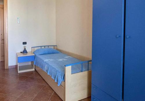 a bedroom with a blue bed and a night stand at Le Residenze Blu Sardinia in La Caletta