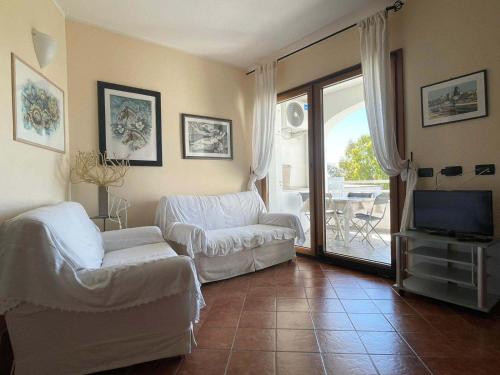 a living room with a couch and a tv at Le Residenze Blu Sardinia in La Caletta