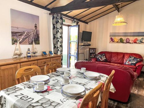 a living room with a table and a red couch at Holiday Home Zeewind 145 by Interhome in Bredene