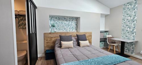 ein Schlafzimmer mit einem großen Bett mit blauen Kissen in der Unterkunft Les gîtes des Landes in Basse-Goulaine