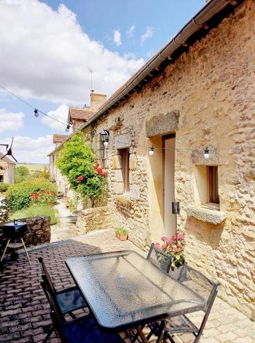 - une table et des chaises sur une terrasse à l'extérieur du bâtiment dans l'établissement La Garencière - Les Hirondelles, à Champfleur
