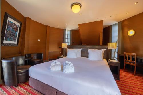 a hotel room with a large white bed with two towels at Grand Hotel Amrâth Amsterdam in Amsterdam