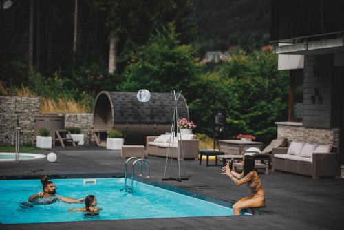 dwie kobiety bawiące się w basenie w obiekcie Czarny Kamień Resort & SPA w Szklarskiej Porębie