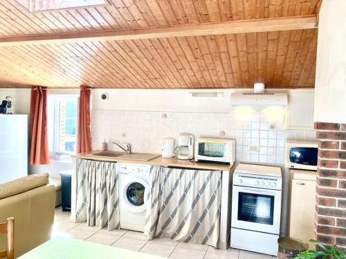 a kitchen with a washing machine and a washer at Maison en pierre au Lac du Jaunay in Saint-Julien-des-Landes