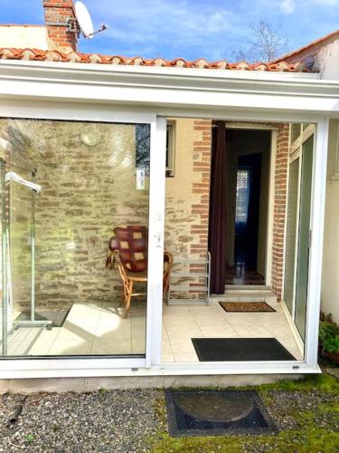 a sliding glass door of a house with a patio at Maison en pierre au Lac du Jaunay in Saint-Julien-des-Landes