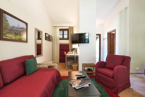 a living room with a red couch and two chairs at Lodge Golf Villa d'Este in Montorfano