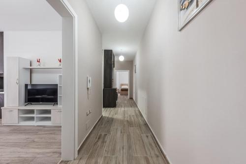 a hallway with white walls and a television and a living room at City Escape Apartment in Shkodër
