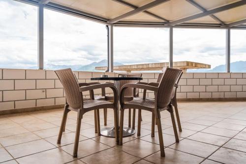 a table and four chairs on a balcony at City Escape Apartment in Shkodër