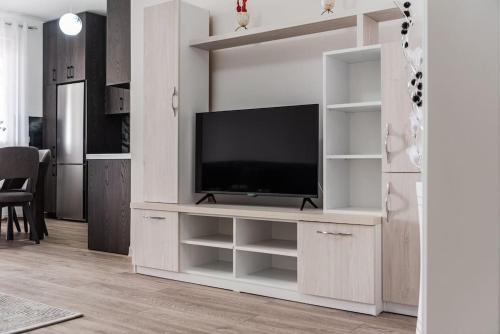 a living room with a tv in a white entertainment center at City Escape Apartment in Shkodër