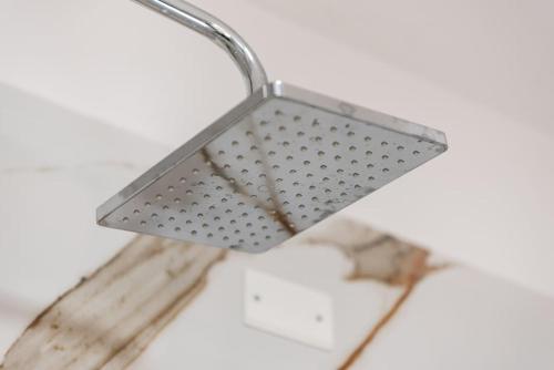 a metal light fixture hanging from a ceiling at City Escape Apartment in Shkodër